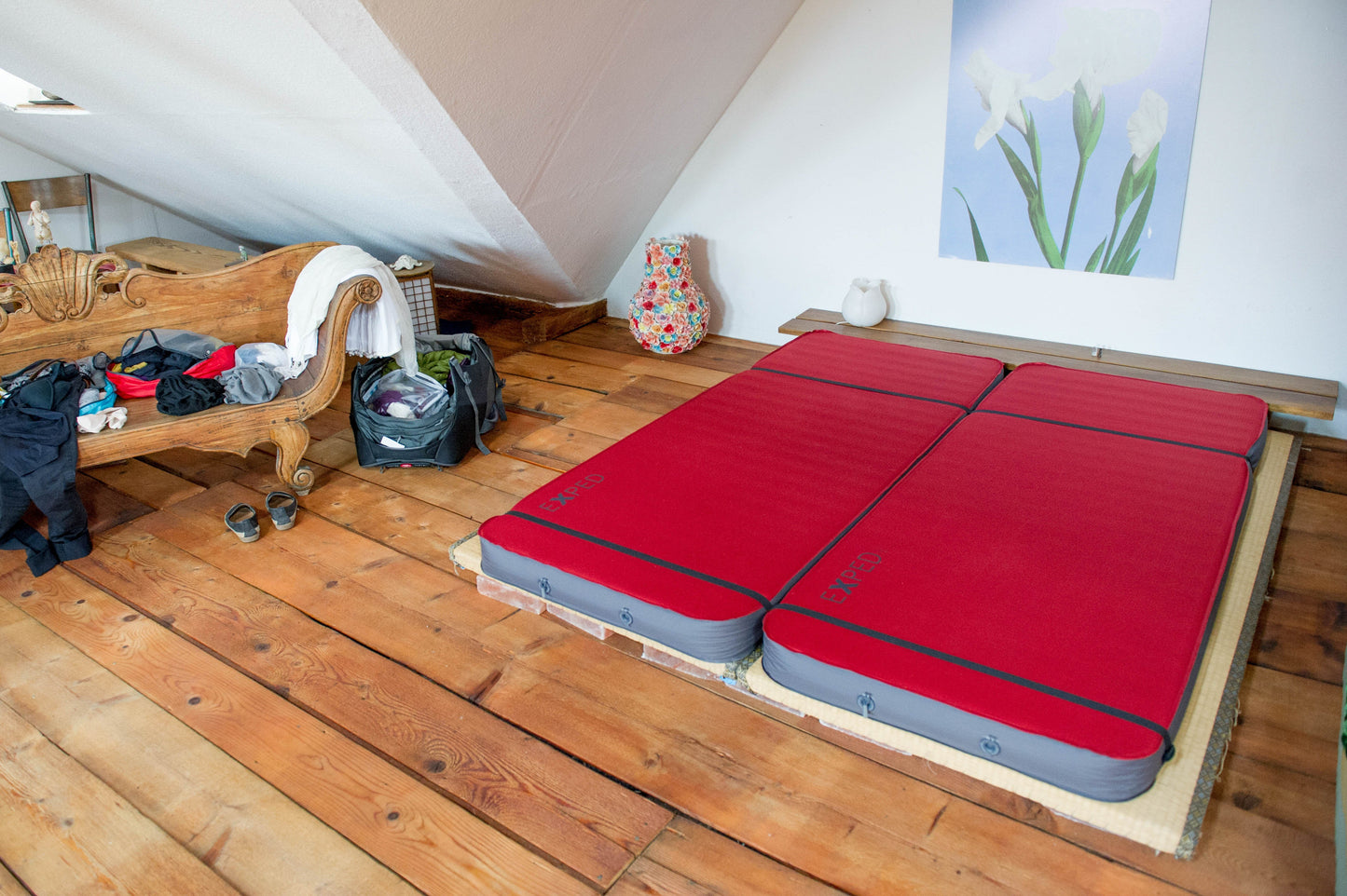 Two EXPED MegaMats on the floor in a small room. Mats are lashed together with a Universal Mat Coupler Kit.